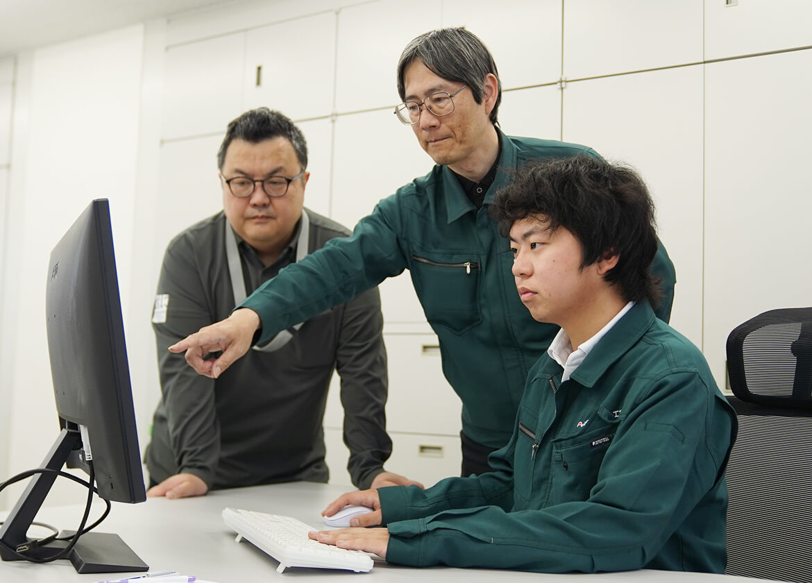 モニターを見ながら打ち合わせをする社員たち